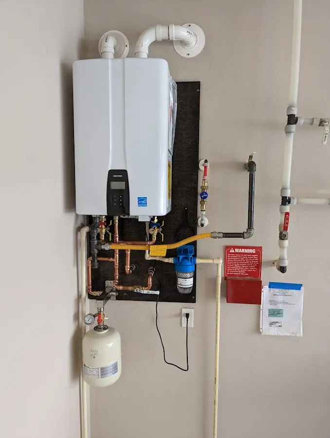 Professional plumber installing copper piping in a Magalia home